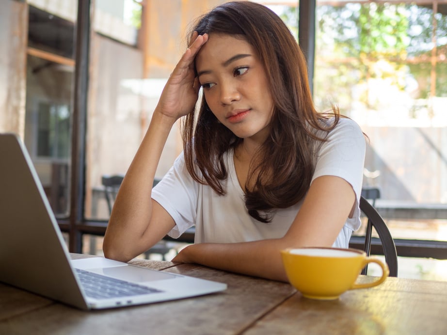 Confused Woman Using Laptop at the Cafe